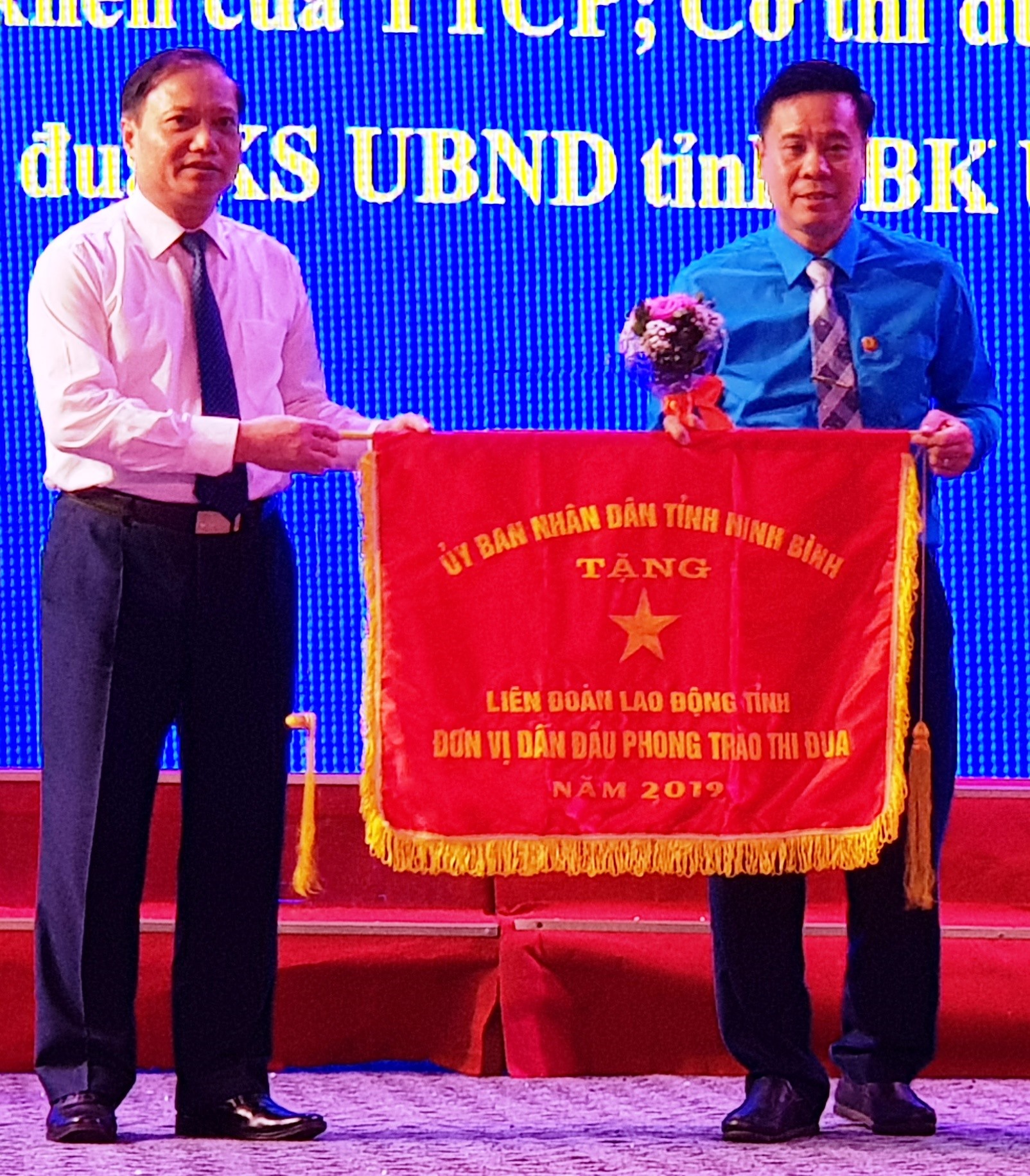 Đại diện lãnh đạo tỉnh Ninh Bình tặng Cờ thi đua xuất sắc cho LĐLĐ tỉnh Ninh Bình. Ảnh: NT