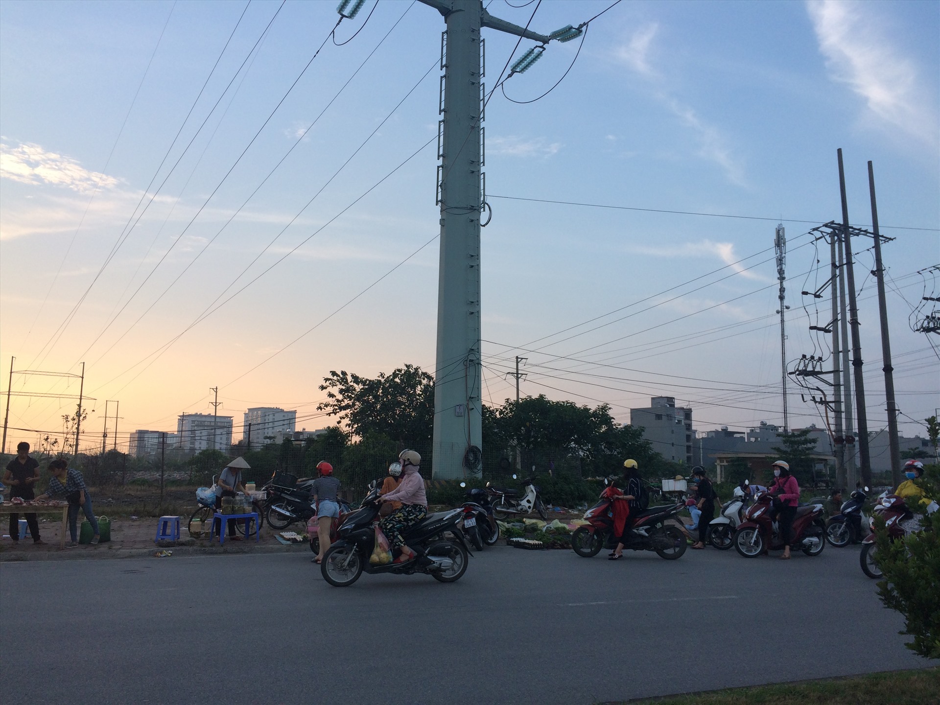 Nhiều người dân vẫn ngồi trên xe máy ngay lòng đường để mua đồ cho tiện lợi. Ảnh: Bảo Hân.