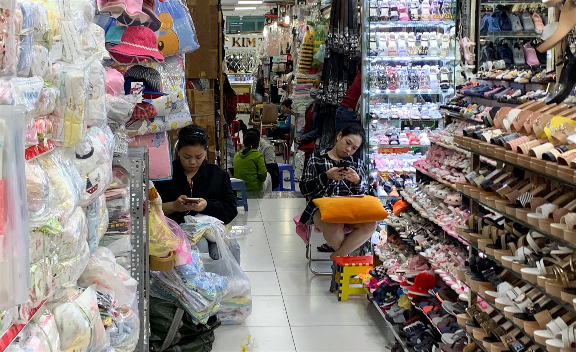 Chợ An Đông vắng khách, các tiểu thương chỉ biết ngồi lướt điện thoại để giết thời gian. Ảnh: Ngọc Lê