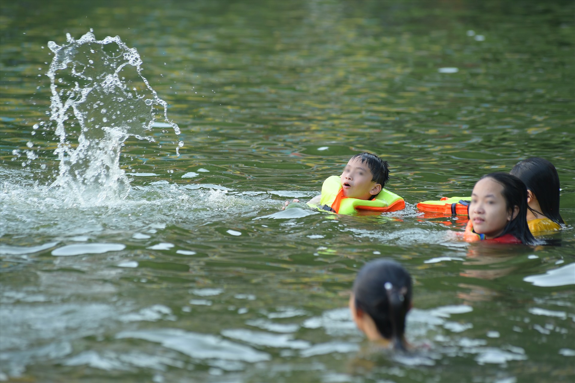 Trẻ em thường bơi gần bờ và xung quanh nhà nổi giữa hồ, ở khu thủy đình - nơi múa rối nước vào mùa lễ hội.