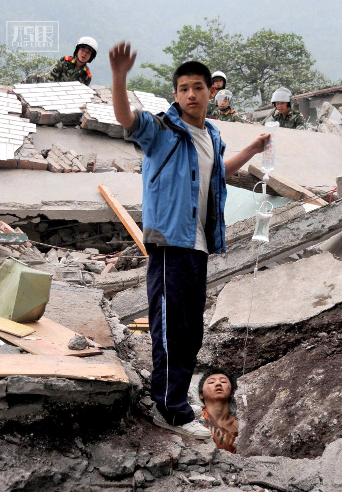 Ngày 13.5, cậu bé Liêu Ba bị vùi trong đống đổ nát tại trung tâm khu vực động đất và bị thương nghiêm trọng. Bạn thân của cậu, Lý Dương, vẫn luôn đứng cầm bình truyền dịch thay cậu. Sau vụ động đất, Liêu Ba được cứu sống. Ảnh: Theo Reuters