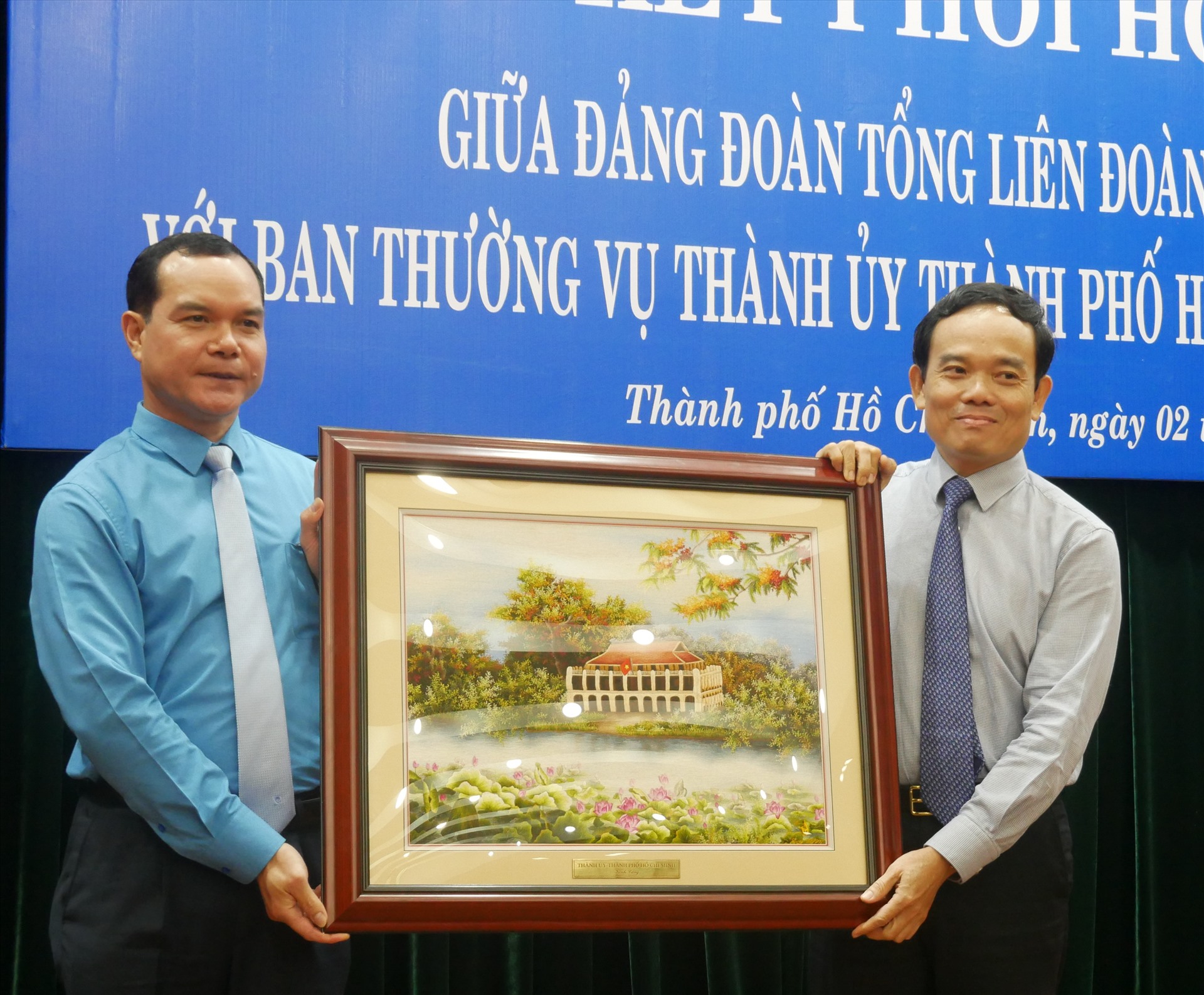 Đồng chí Trần Lưu Quang (bên phải), Phó Bí thư Thường trực Thành ủy TPHCM tặng tranh lưu niệm cho Tổng LđLĐ Việt Nam. Ảnh Hà Phương