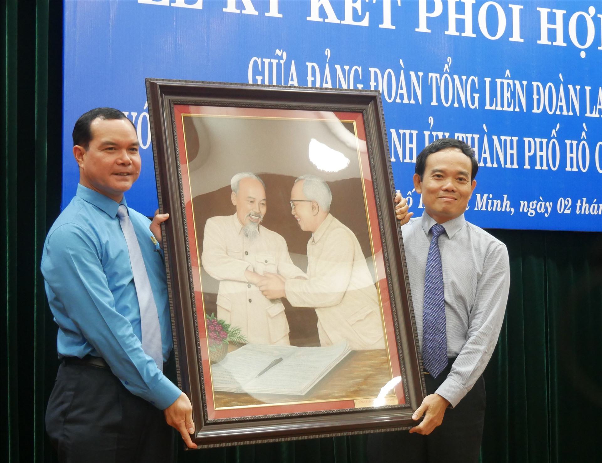 Đồng chí Nguyễn Đình Khang (bên trái), tặng tranh Bác Hồ - Bác Tôn cho Ban thường vụ Thành ủy TPHCM. Ảnh Hà Phương