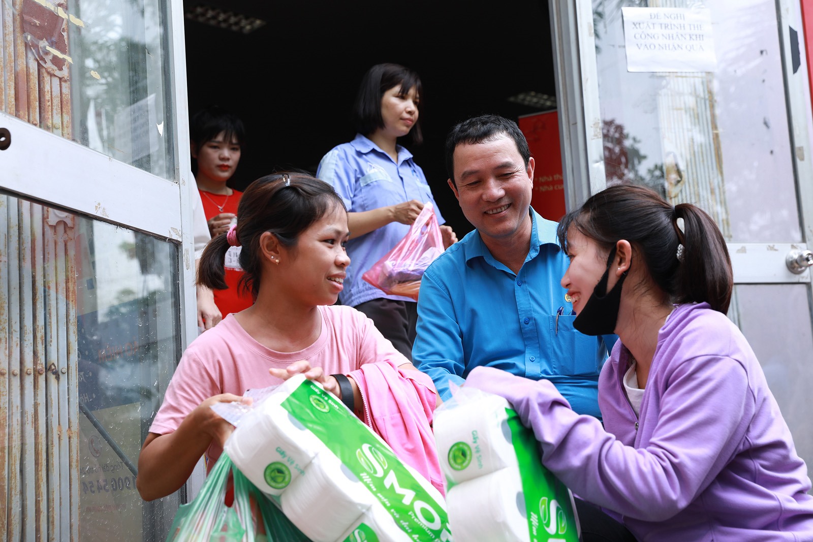 Chủ tịch Công đoàn các Khu công nghiệp và chế xuất Hà Nội hỏi thăm công nhân lao động về các mặt hàng họ đã mua.