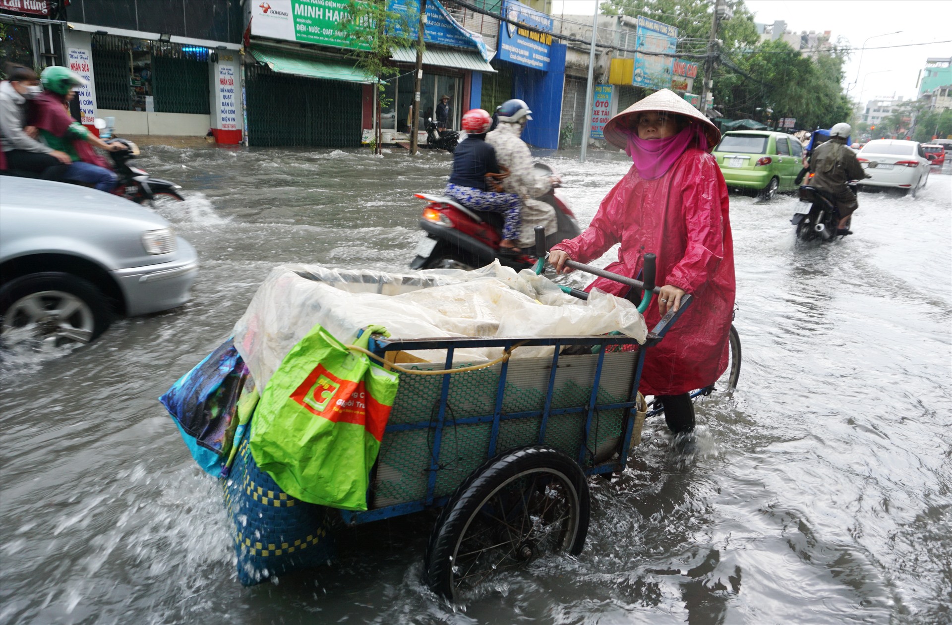 Tại đường Đinh Bộ Lĩnh sau mưa 20 phút, mặt đường đã lênh láng nước. Đoạn đường bị ngập dài gần 1km, có đoạn ngập sâu hơn nửa bánh xe khi người dân di chuyển khó khăn.