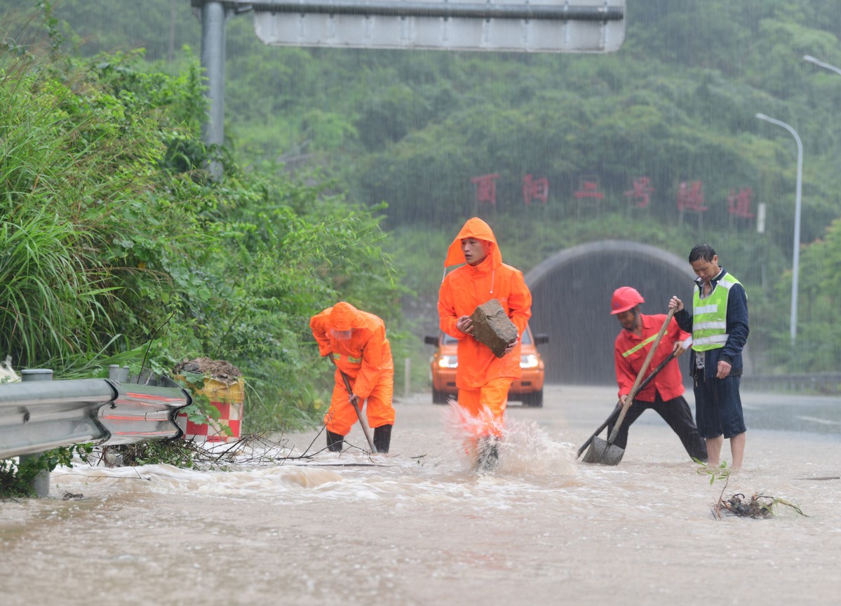 Nhân viên cứu hộ đang dọn đá rơi xuống đường do mưa lớn ở Trùng Khánh. Ảnh: Xinhua