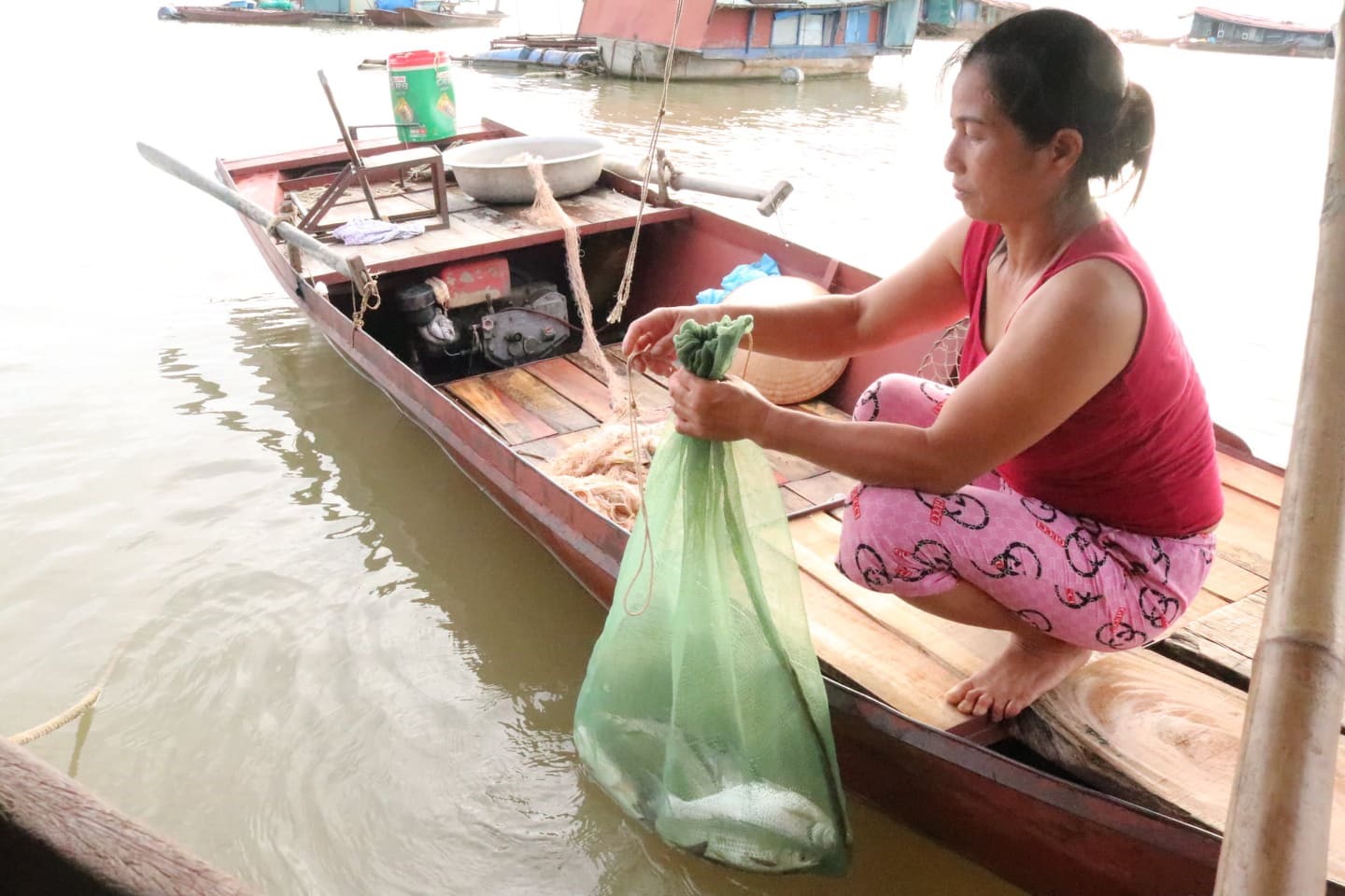 Bà Trần Thị Hương tranh thủ thả thêm mẻ lưới để kiếm thêm thu nhập cho gia đình.