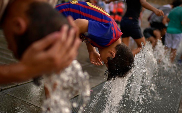 Người dân thành phố Vitoria, miền Bắc Tây Ban Nha, tận hưởng dòng nước mát giữa cái nắng nóng gay gắt của mùa Hè. Ảnh: AFP