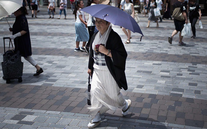 Một phụ nữ Nhật Bản đi dưới trời nắng nóng ở Tokyo, Nhật Bản. Trong tháng 7, nhiều khu vực ở Nhật Bản đã ghi nhận nắng nóng kỷ lục với nhiệt độ lên tới 41,1 độC. Ảnh: AFP