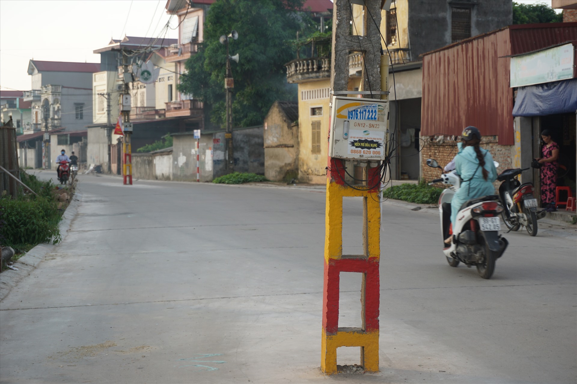 Lãnh đạo địa phương cho hay, những cột điện không được di chuyển vì không nằm trong dự án nâng cấp tuyến đường. Ảnh: Long Nguyễn.