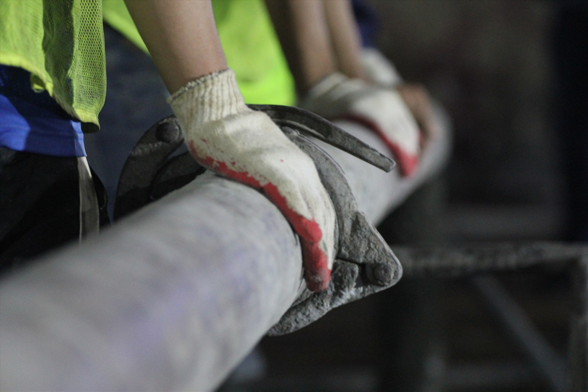 Trong quá trình nhận bê tông, một vài công nhân liên tục phải dùng búa đập vào các điểm nối để tránh bê tông bị nghẽn. Một vài công nhân dùng tay giữ lại ống bê tông.