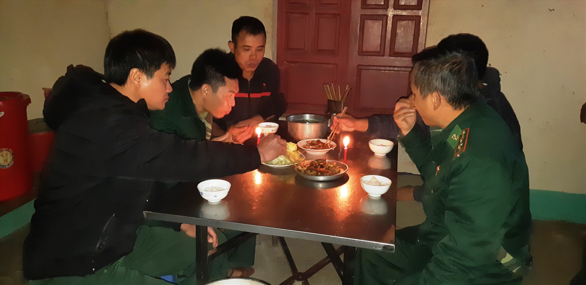 Bữa cơm trưa đơn giản của các chiến sĩ trạm Biên phòng Buộc Mú bên ánh nến lập lòe. Ảnh: Trần Tuyên
