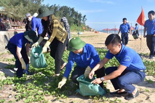 Các đoàn viên tham gia thu gom rác làm sạch bãi biển. Ảnh: TĐ.