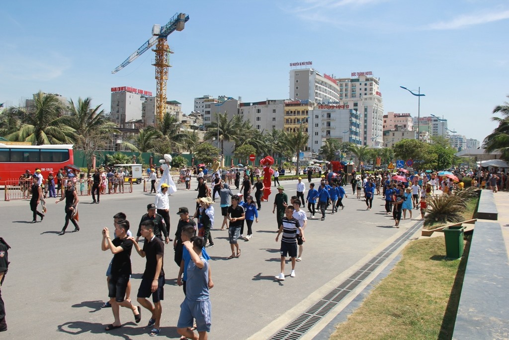 Hàng nghìn người dân, du khách đã hứng khởi đội nắng, tham gia diễu hành dọc bãi biển Sầm Sơn. Ảnh: Quách Du