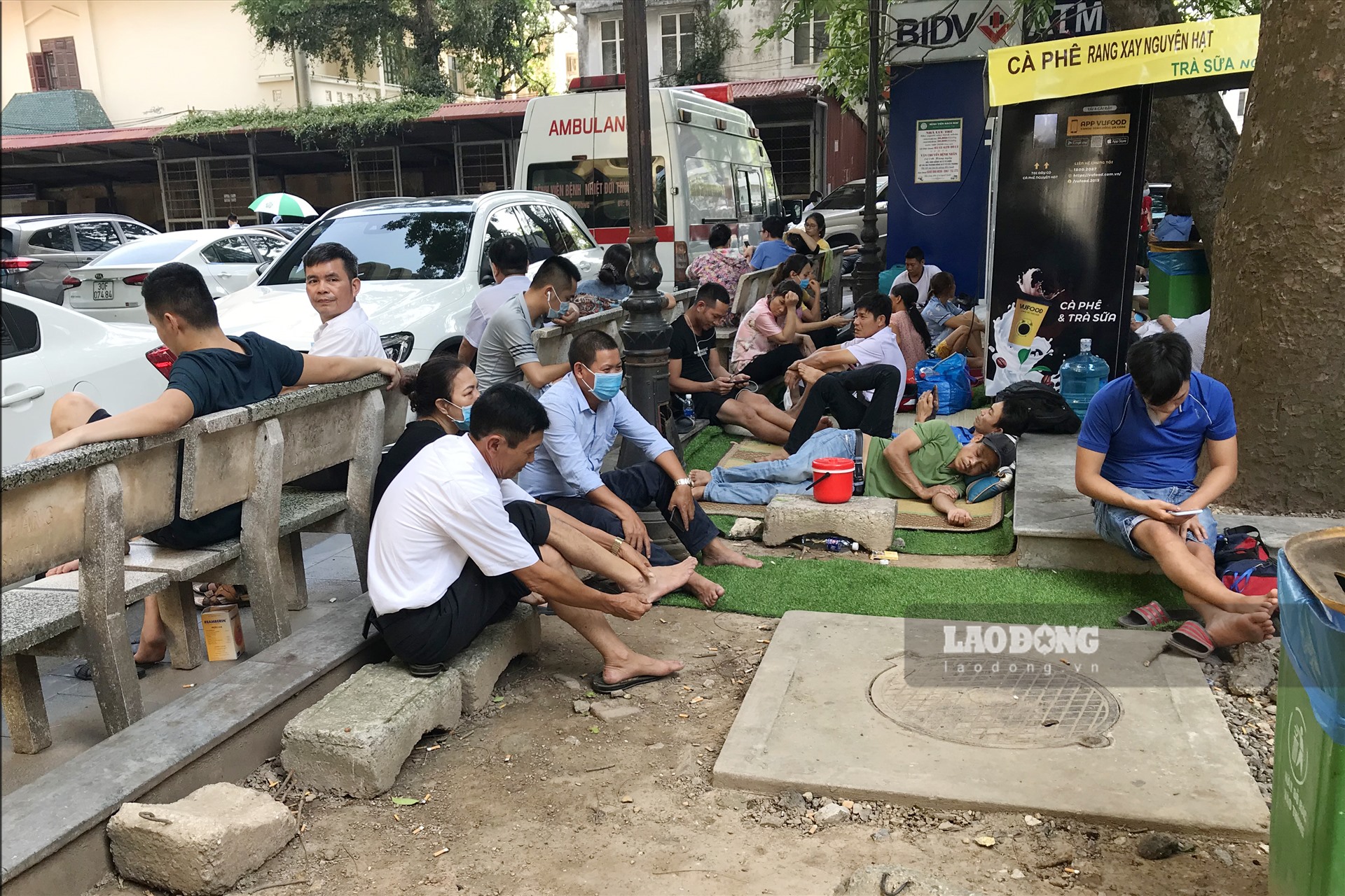 Sáng 2/6, ghi nhận tại bệnh viện Bạch Mai người bệnh và người nhà bệnh nhân nằm, ngồi la liệt tại các khu vực hành lang, tranh thủ tìm nơi râm mát để “trốn” nắng nóng gay gắt của mùa hè.