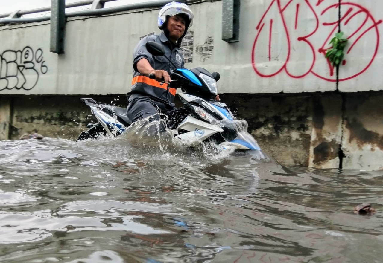 Nước ngập hết bánh xe máy trên đường Nguyễn Hữu Cảnh.  Ảnh: Minh Quân