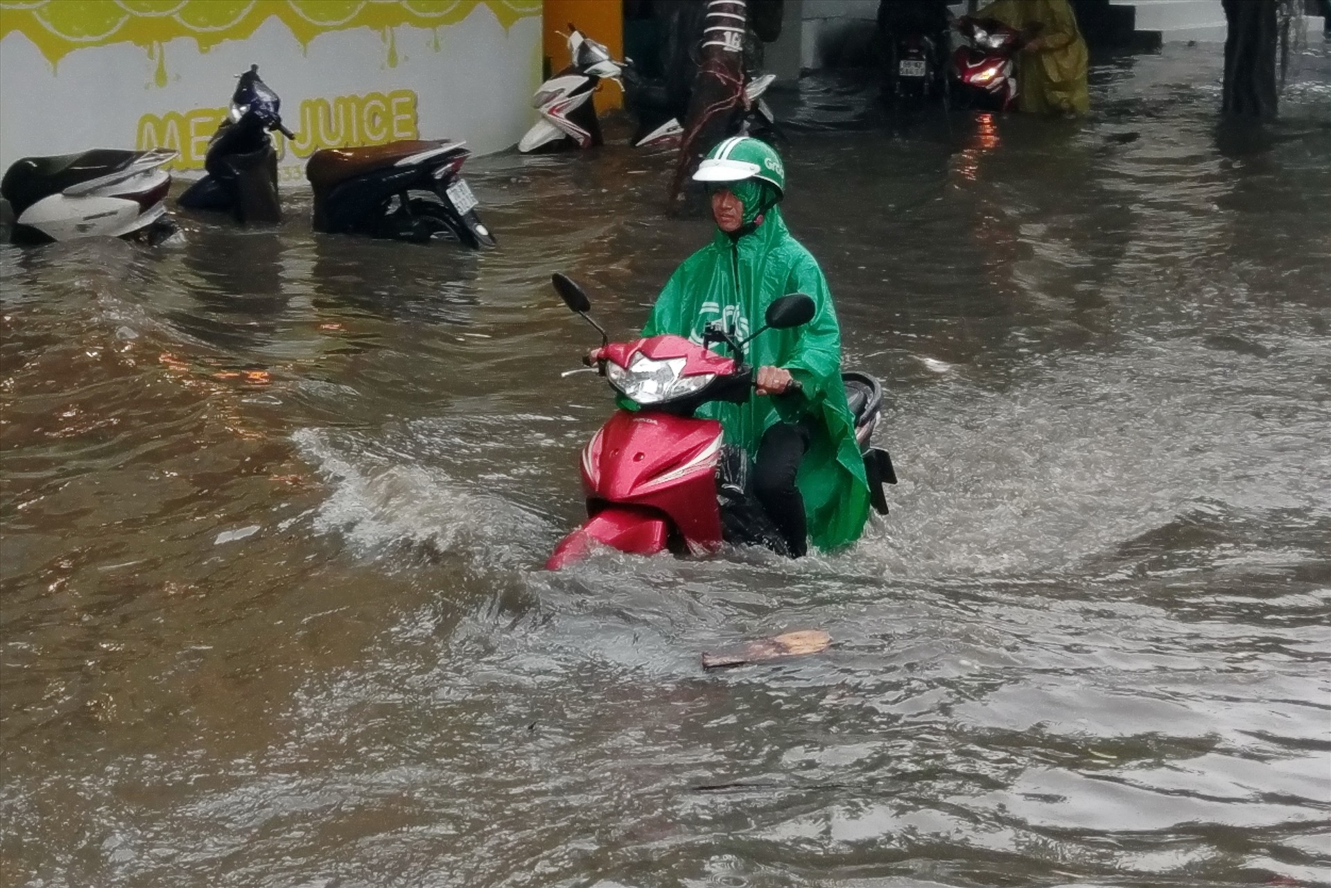 Tại chân cầu vượt Nguyễn Hữu Cảnh, dù mưa đã tạnh nhưng nước vẫn ngập sâu lút bánh xe máy.