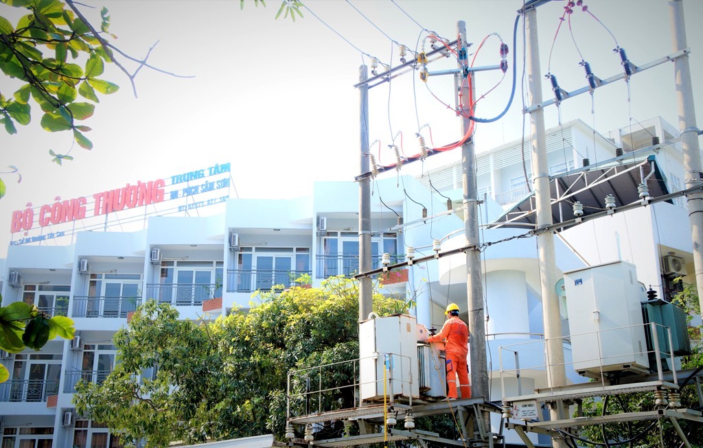 Các công nhân Điện lực TP. Sầm Sơn thực hiện việc rửa sứ, bảo dưỡng lưới điện. Ảnh: Q.D