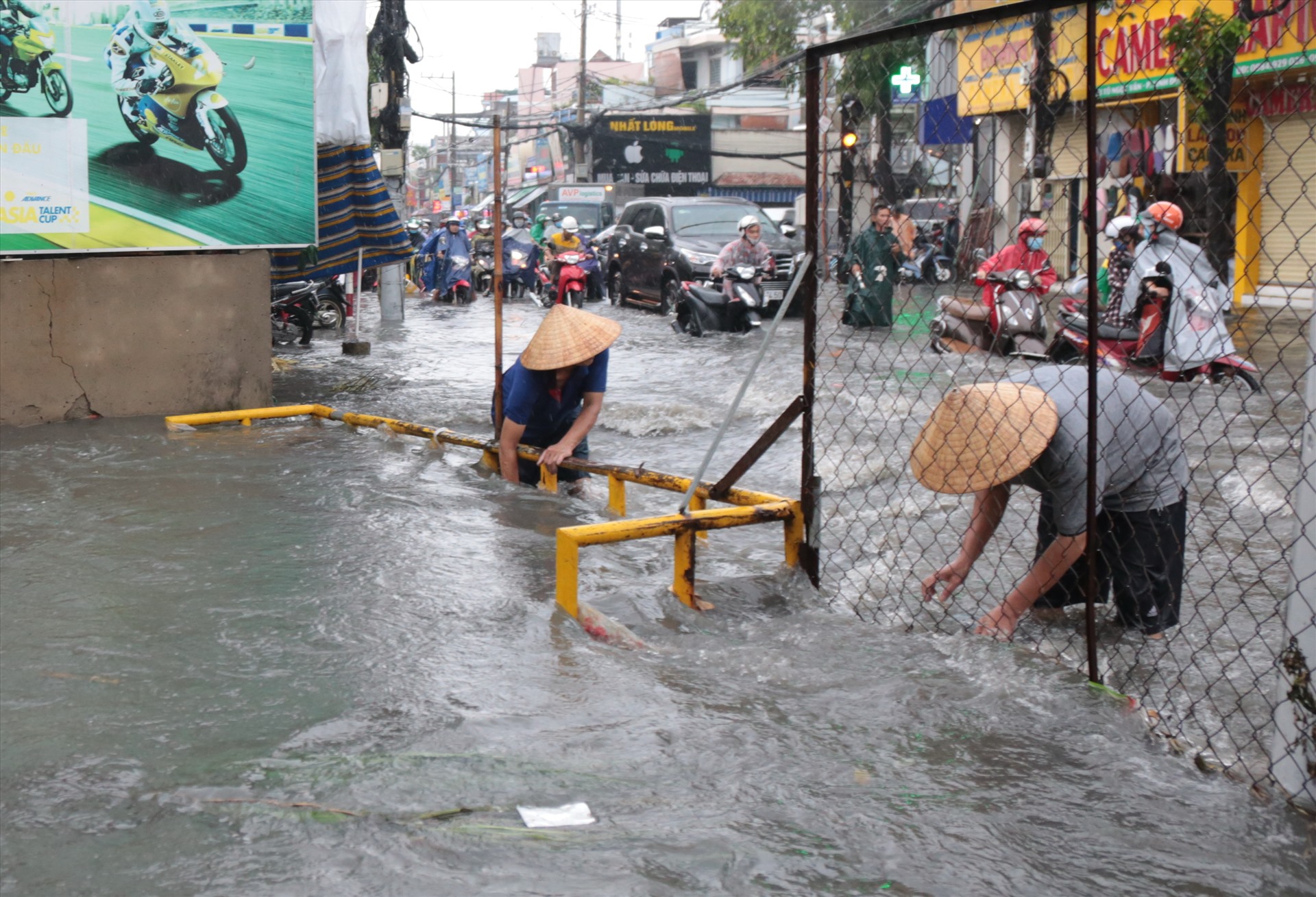 Người dân phải gỡ rác chặn ngang kênh để nước thoát nhanh hơn.