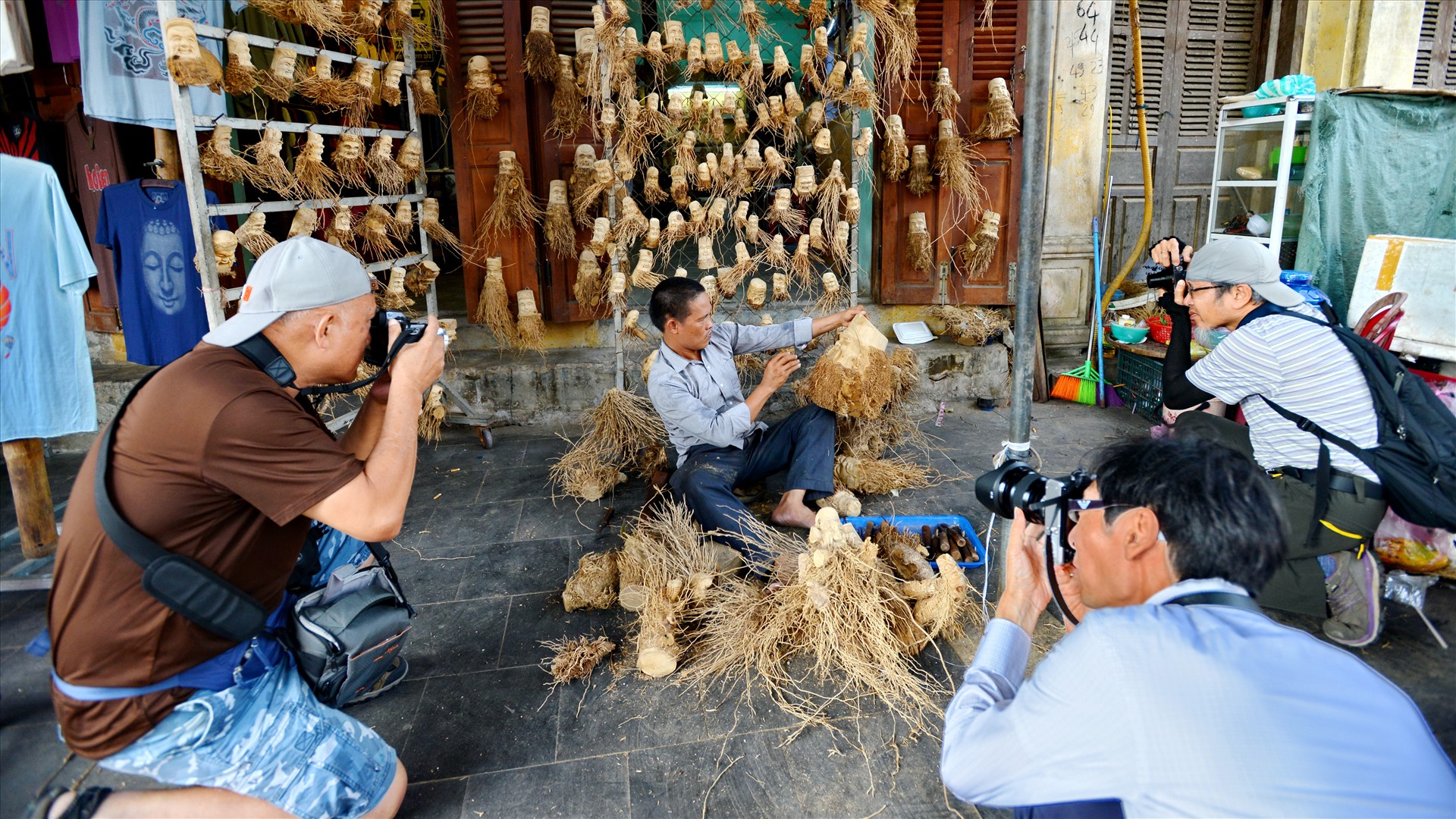 Du khách Nhật Bản chụp ảnh nghệ nhân nghề truyền thống ở phố cổ Hội An.  Ảnh: Thái Hoàng
