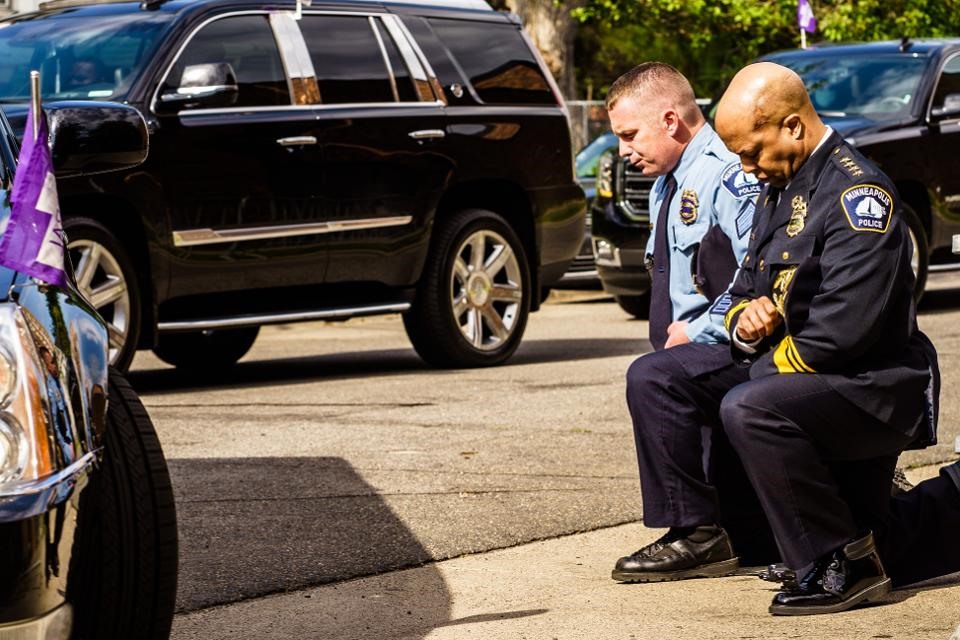 Cảnh sát trưởng thành phố Minneapolis Medaria Arradondo (phải) quỳ xuống khi xe tang của Floyd đi qua. Ảnh: AFP