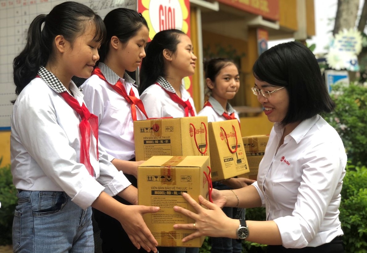 Chị Việt Hòa đại diện công ty cổ phần Bóng đèn phích nước Rạng Đông tặng đèn cho các em học sinh. Ảnh: S.H