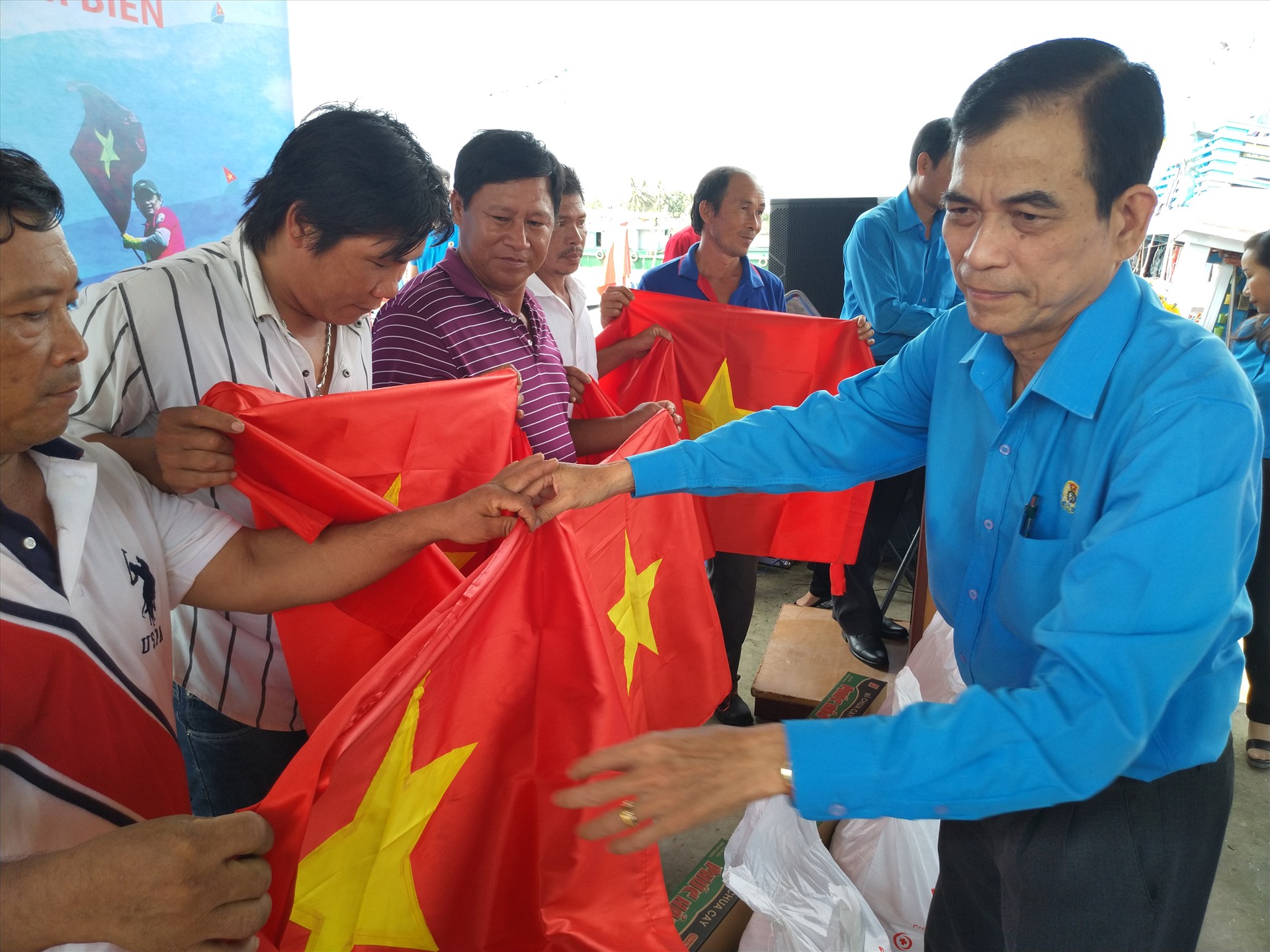 Chủ tịch LĐLĐ tỉnh Tiền Giang trao cờ cho ngư dân. Ảnh: K.Q