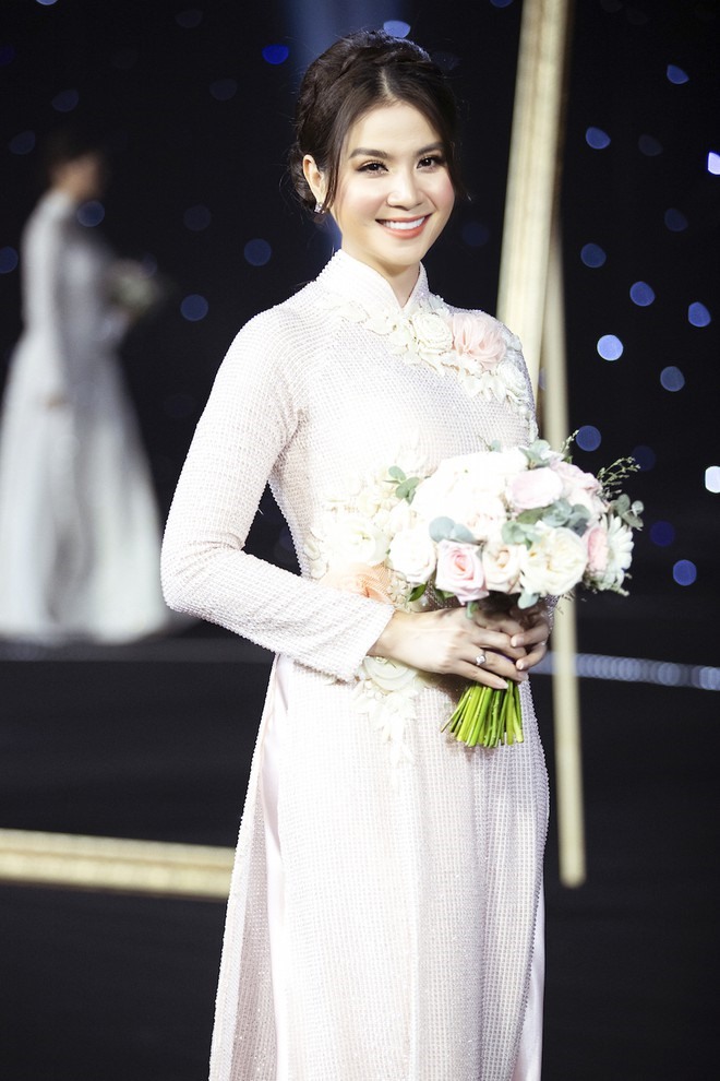 Kha Ly tái hiện lại khoảnh khắc kết hôn trên sân khấu khi diện mẫu áo dài trắng có điểm nhấn là bông hoa được thêu tay đầy độc đáo phía bên ngực phải.