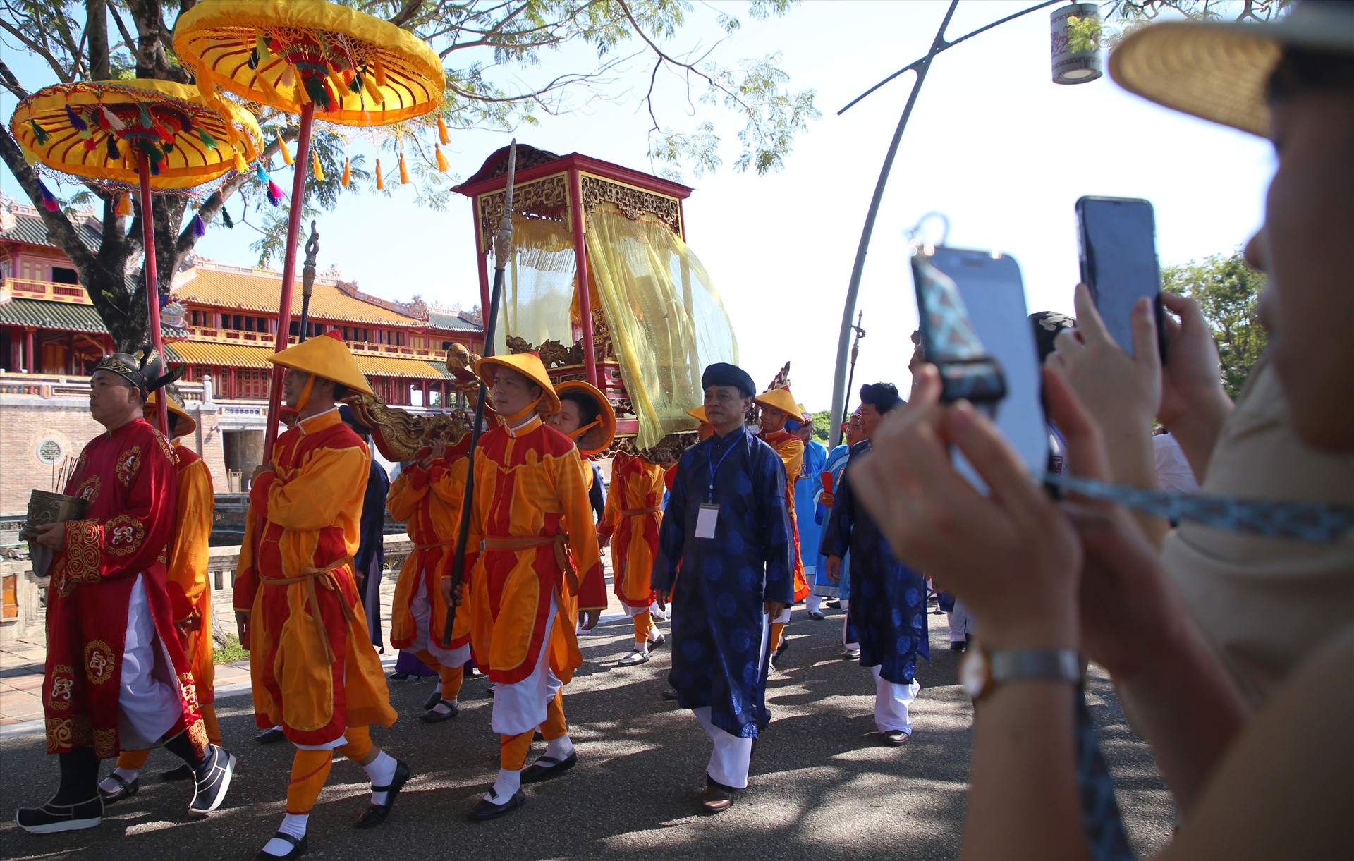 Ở ngoài khuôn viên Đại nội Huế, nhiều người dân tò mò với nghi lễ rước Long vị vua nên dùng điện thoại ghi lại hình ảnh.
