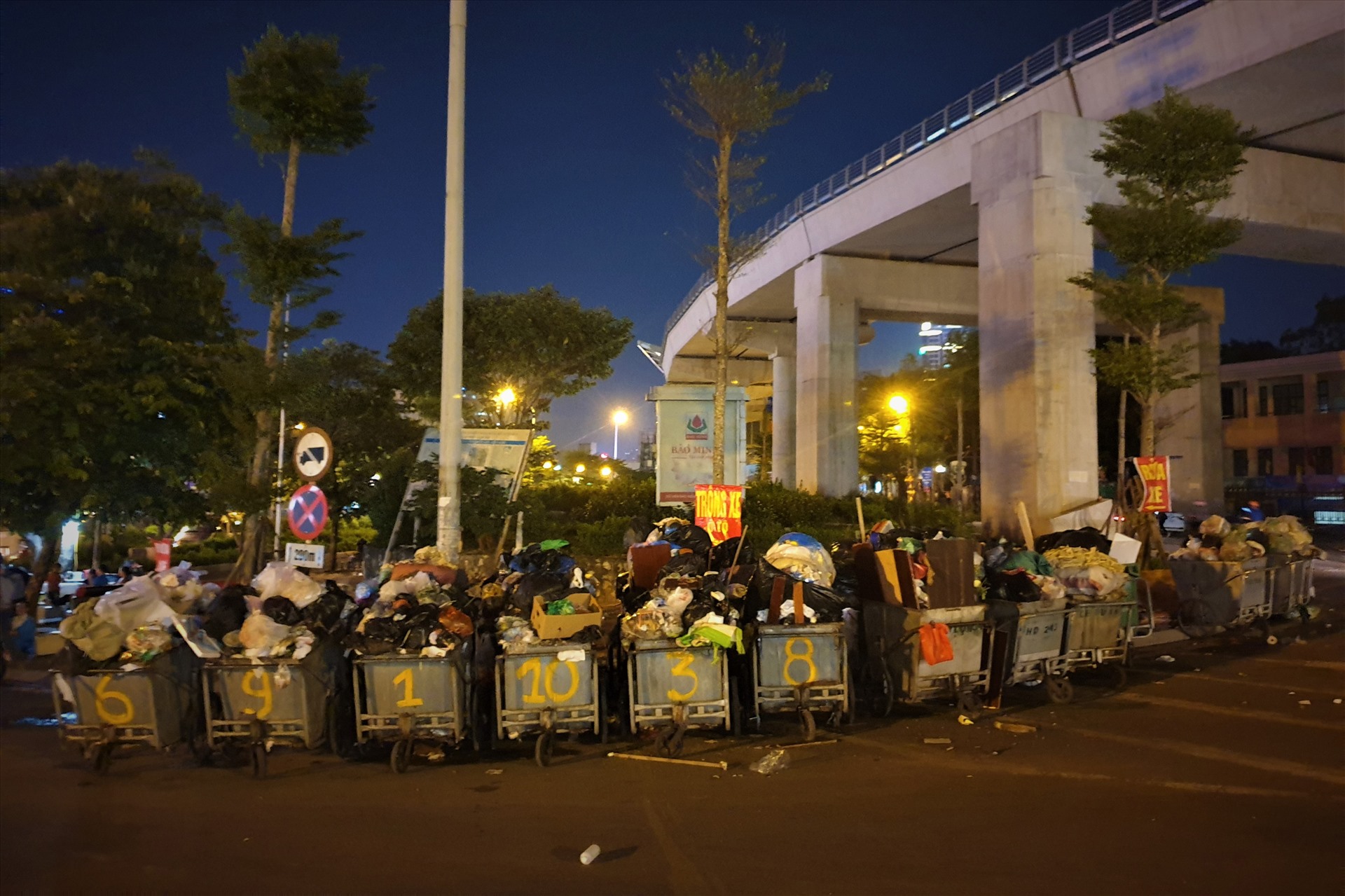 Tại nút giao Kim Mã - Đê La Thành, phố Chùa Láng, hàng dài xe gom rác vẫn phủ bạt chờ cẩu đến điểm tập kết.