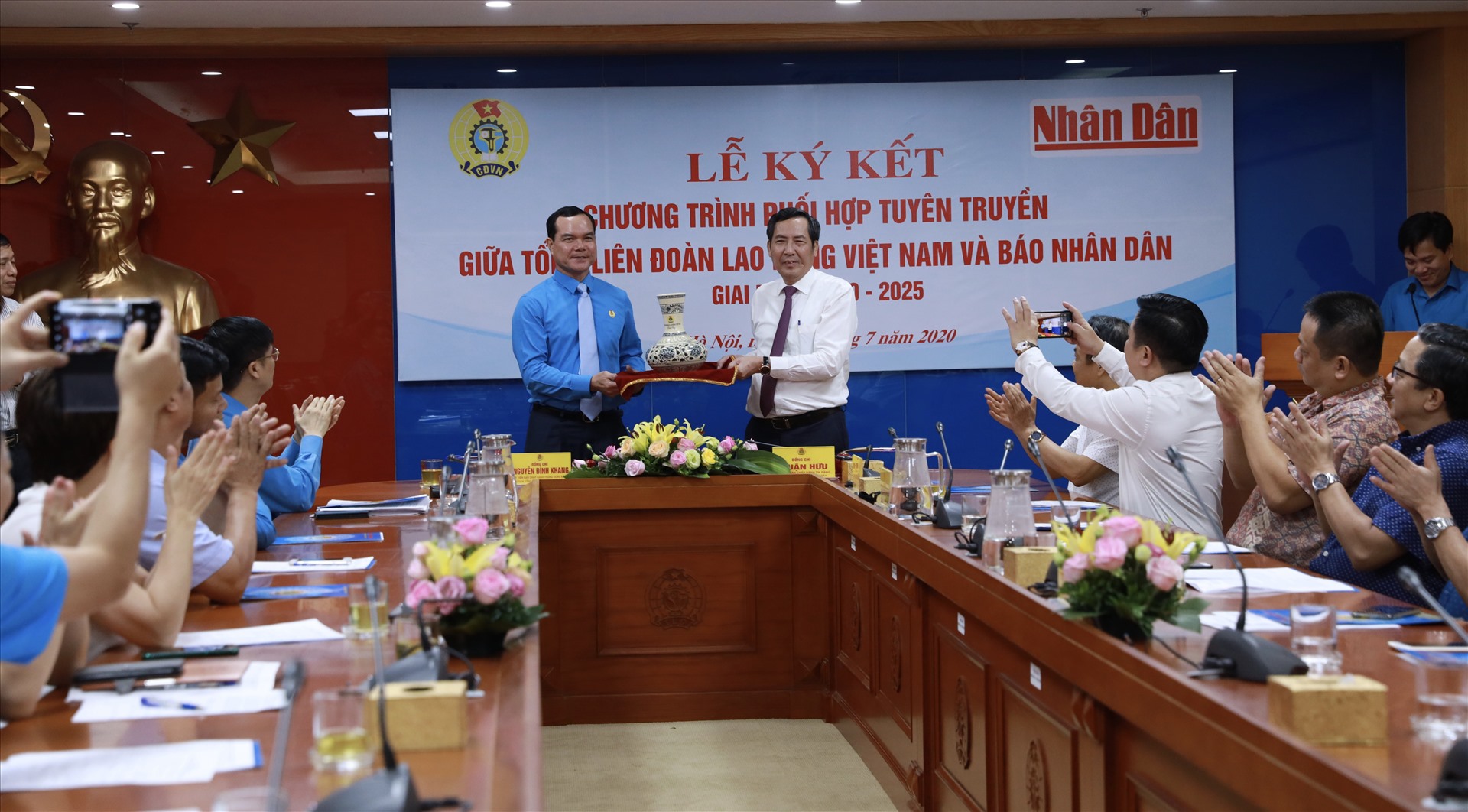 Đồng chí Nguyễn Đình Khang (bên trái) tặng quà lưu niệm tới lãnh đạo Báo Nhân Dân. Ảnh: Hải Nguyễn