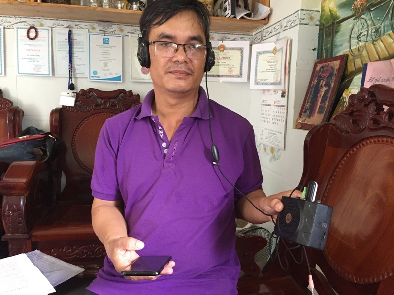Thầy Lê Văn Cương bên thiết bị dạy học là chiếc điện thoại kết nối bluetooth dạy Tiếng Anh. Ảnh: Nguyên Dũng