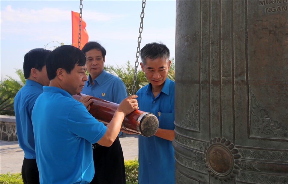 Đồng chí Trần Văn Thuật (bìa phải ảnh) cùng các thành viên trong đoàn thỉnh chuông ở Nghĩa trang liệt sĩ Quốc gia Trường Sơn. Ảnh: Hưng Thơ.