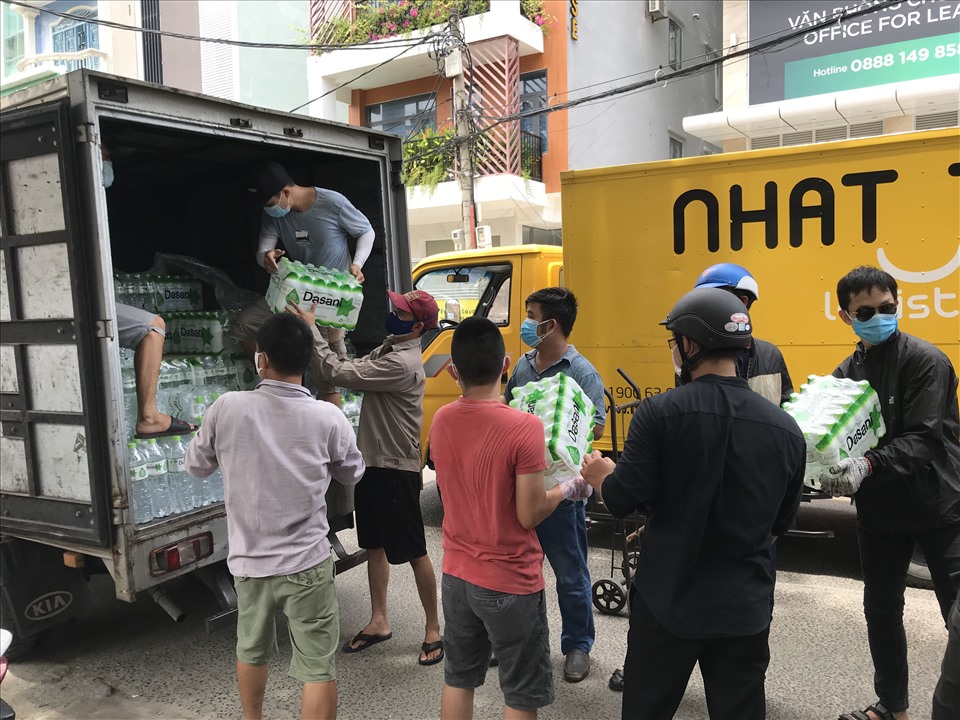 Dù vào giữa trưa nắng nhưng người dân Đà Nẵng vẫn tấp nập chuyển những thùng hàng đến các y bác sĩ bên trong khu cách ly. Ảnh: Mai Hương
