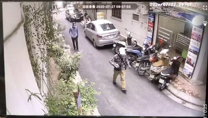 Hai tên cướp mặc áo chống nắng, đeo khẩu trang, đi bộ vào ngân hàng BIDV. Ảnh cơ quan công an cắt từ clip.