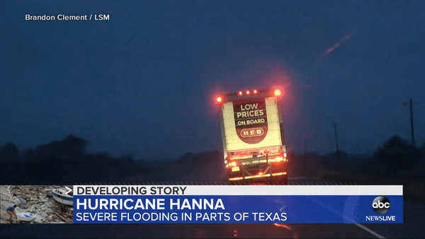 Một chiếc xe tải chở hàng bị gió bão thổi lật ngang trên đường di chuyển. Ảnh: NBC News