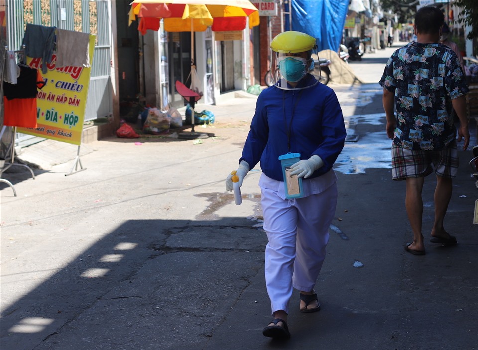 Nhân viên y tế trong trang phục bảo hộ kiểm tra khu vực nghi có ca mắc COVID-19 trên đường Nguyễn Duy Hiệu. Ảnh: Hữu Long