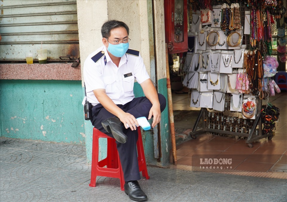 Bảo vệ chợ Bến Thành trực đo thân nhiệt cho hành khách trước khi vào chợ - ảnh Ngọc Lê