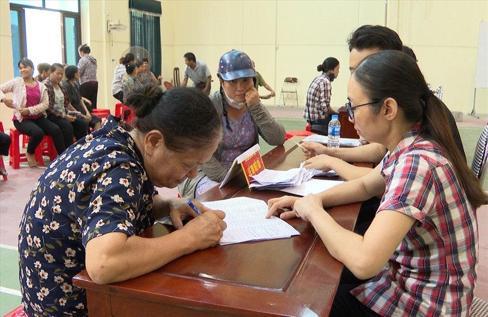 Người dân trên địa bàn thành phố Ninh Bình làm thủ tục nhận tiền hỗ trợ. Ảnh: NT