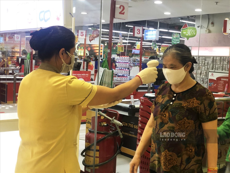 Tại các hệ thống siêu thị ở Hà Nội như BigC, Vinmart... người dân được đo thân nhiệt trước khi vào bên trong.