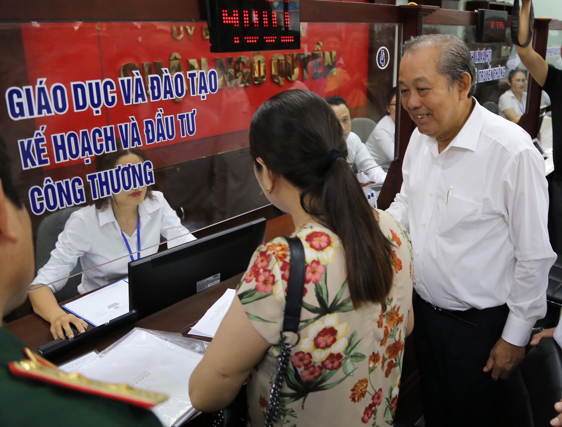 Phó thủ tướng Trương Hòa Bình lắng nghe ý kiến của người dân giao dịch tại Bộ phận một cửa UBND quận Ngô Quyền. Ảnh HP