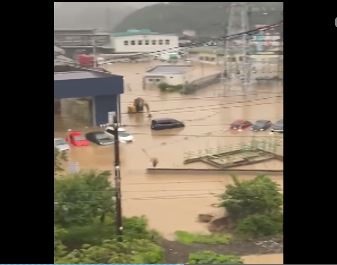 Nước lũ nhấn chìm nhà cửa, xe cộ. Ảnh: NHK