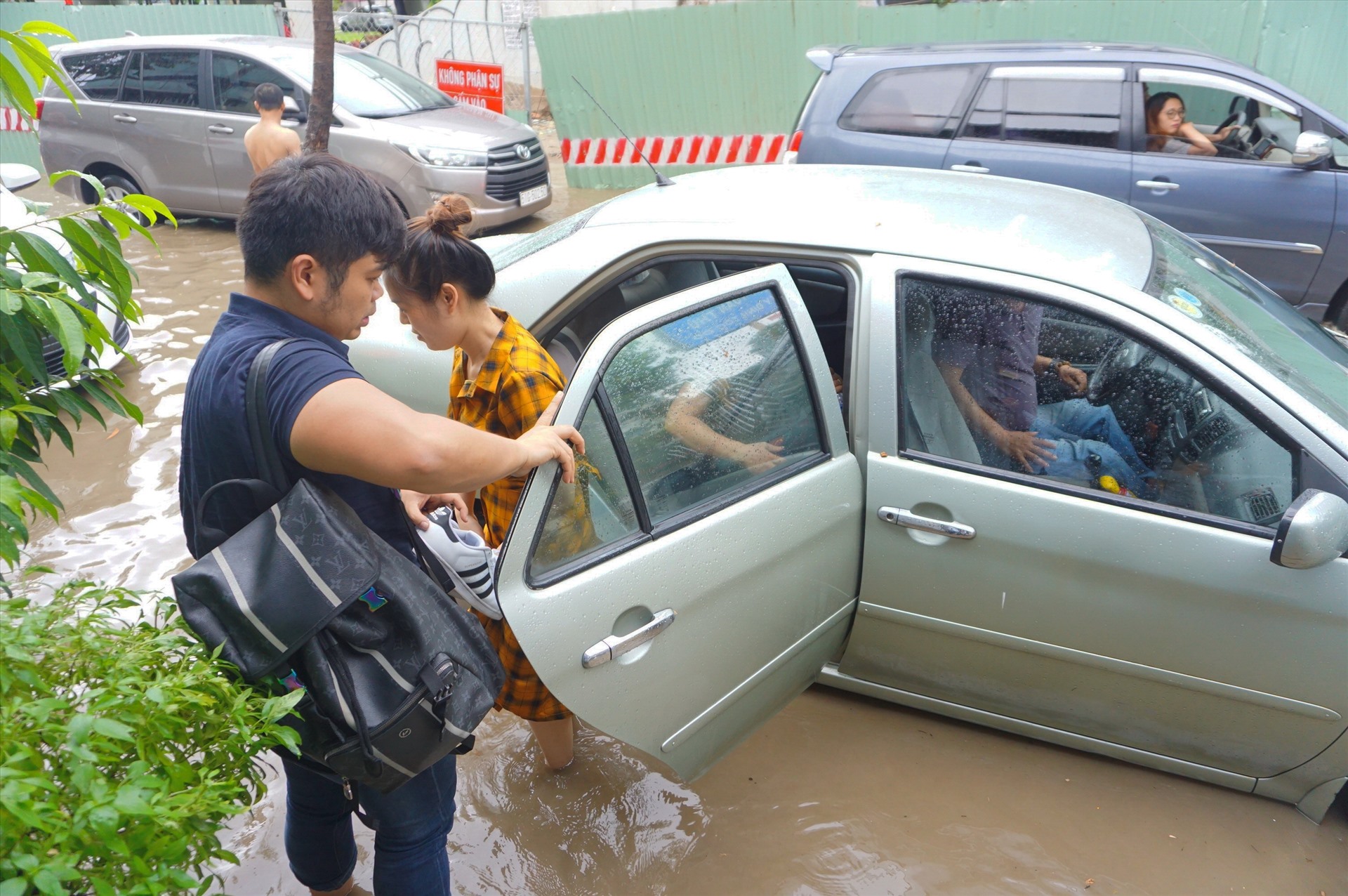 Một chiếc ô tô chết máy trên đường ngập Nguyễn Hữu Cảnh. Những người ngồi trên xe phải xuống xe bì bõm lội nước qua đoạn đường ngập.   Ảnh: Minh Quân