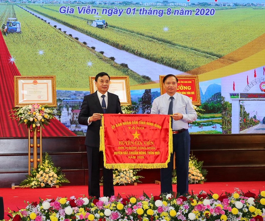 Đại diện lãnh đạo tỉnh Ninh Bình trao tặng cờ thi đua cho huyện Gia Viễn. Ảnh: NT