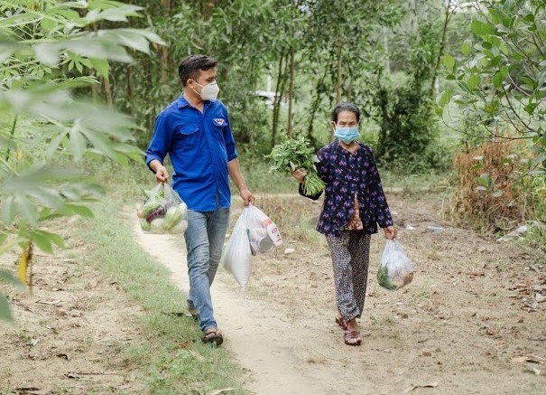 Anh Phan Văn Đức giúp người dân mang thực phẩm về nhà.