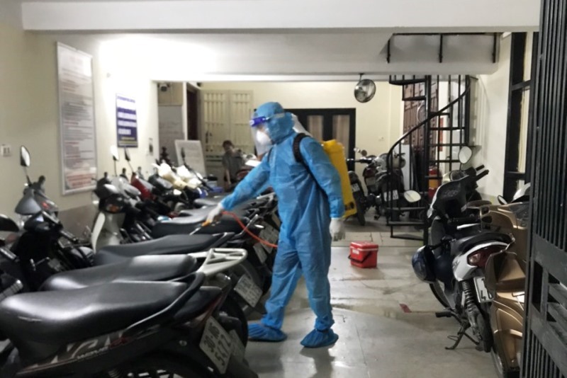 Đội phản ứng nhanh của Trung tâm Y tế quận Thanh Xuân phun khử trùng nơi ở trọ của ca nghi mắc COVID-19. Ảnh: Hồng Thái