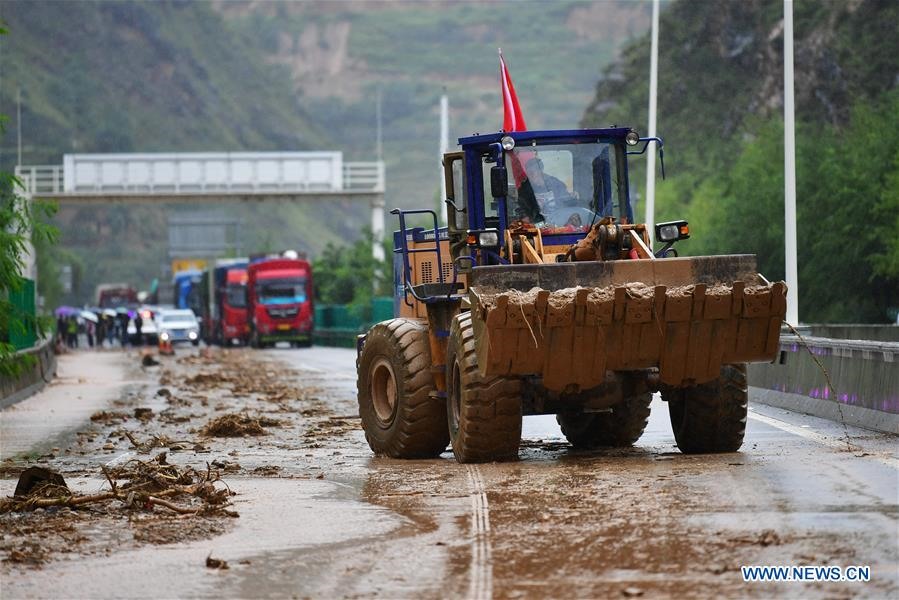 Máy móc được điều đến để khôi phục đường sá bị hư hại do mưa lũ kéo dài. Ảnh: Tân Hoa Xã