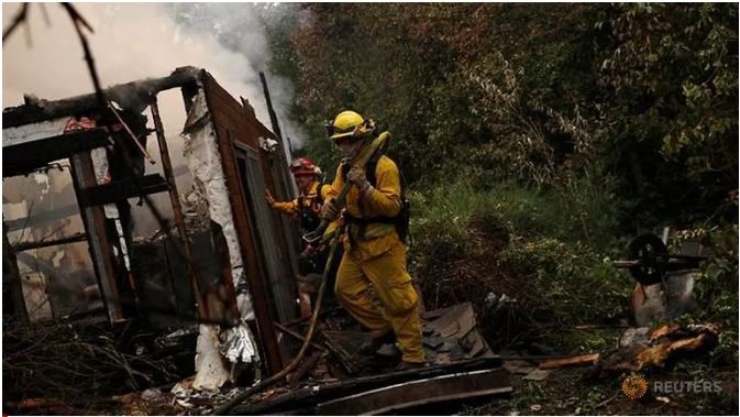 Nhân viên cứu hỏa đang dập tắt đám cháy trong khu vực dân cư ở  ngoại ô Vacaville, California, Mỹ hôm 19.8. Ảnh: Reuters