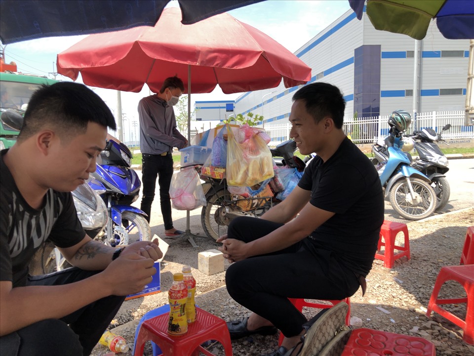 Hai nam thanh niên tại huyện Yên Thế (tỉnh Bắc Giang) ngồi quán nước để chờ đến giờ vào phỏng vấn. Ảnh: Bảo Hân.