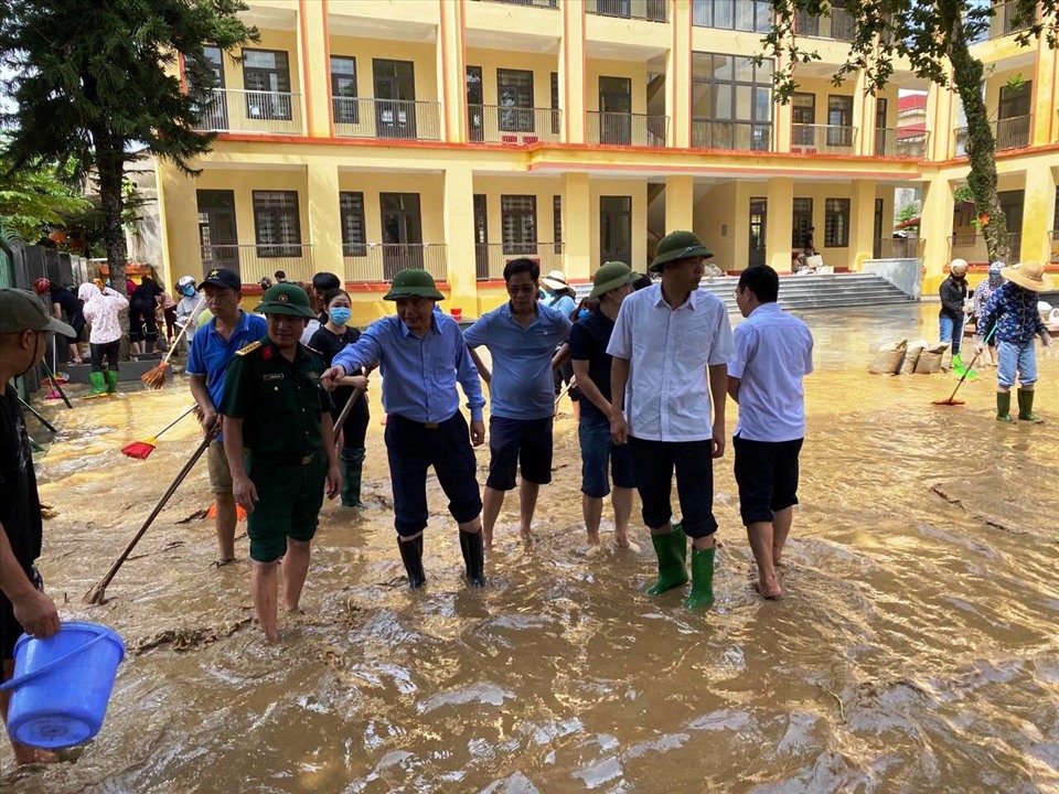 Tổng cục Phòng Chống thiên tai và lực lượng chức năng hỗ trợ giáo viên trường dọn bùn đất bao vây trường học do lũ lụt. Ảnh: Ngọc Hà